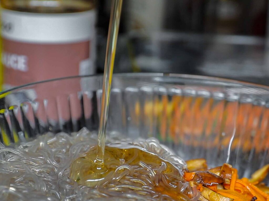 adding syrup to japchae